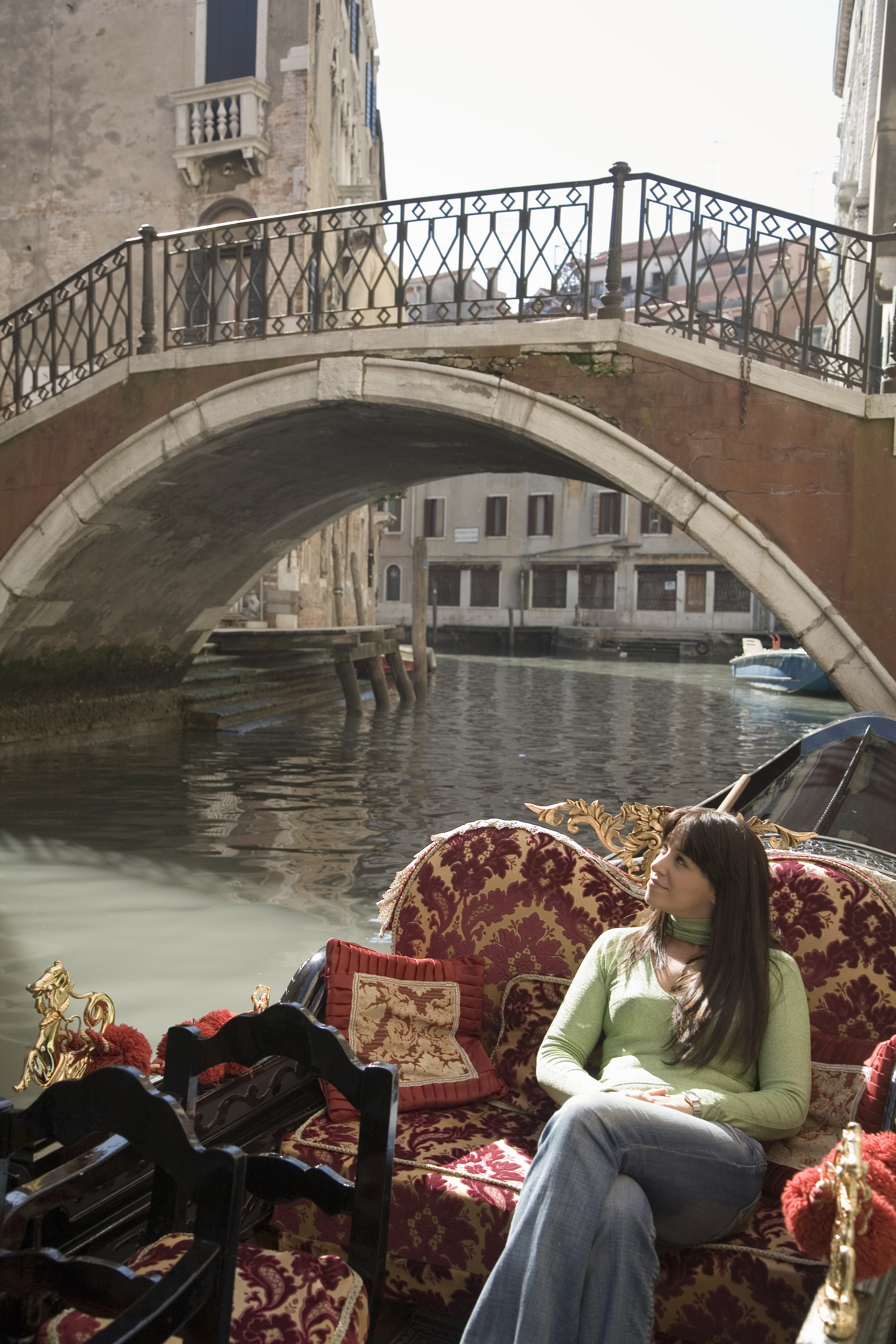 Young woman looking up from canal gondola, Venice, Italy