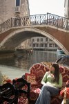 Young woman looking up from canal gondola, Venice, Italy